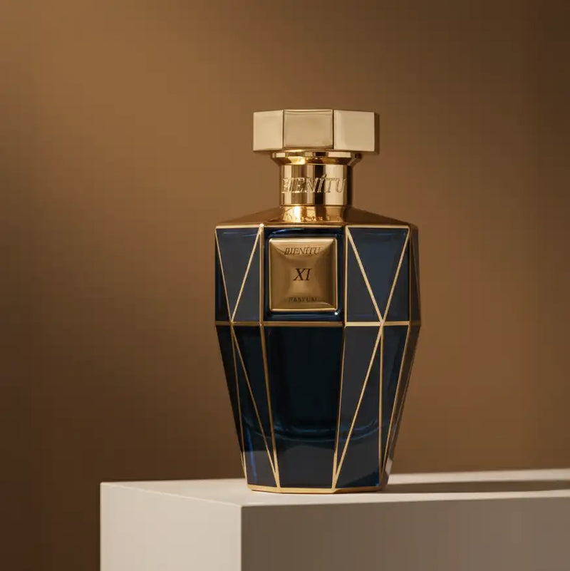 A sleek, deep blue glass perfume bottle with gold geometric accents and a matching hexagonal cap.